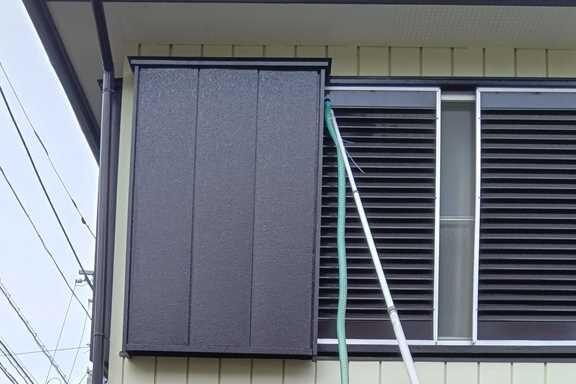 はしご不可の難所（戸袋内）のため、集じん機を使用してスズメバチを駆除している作業風景